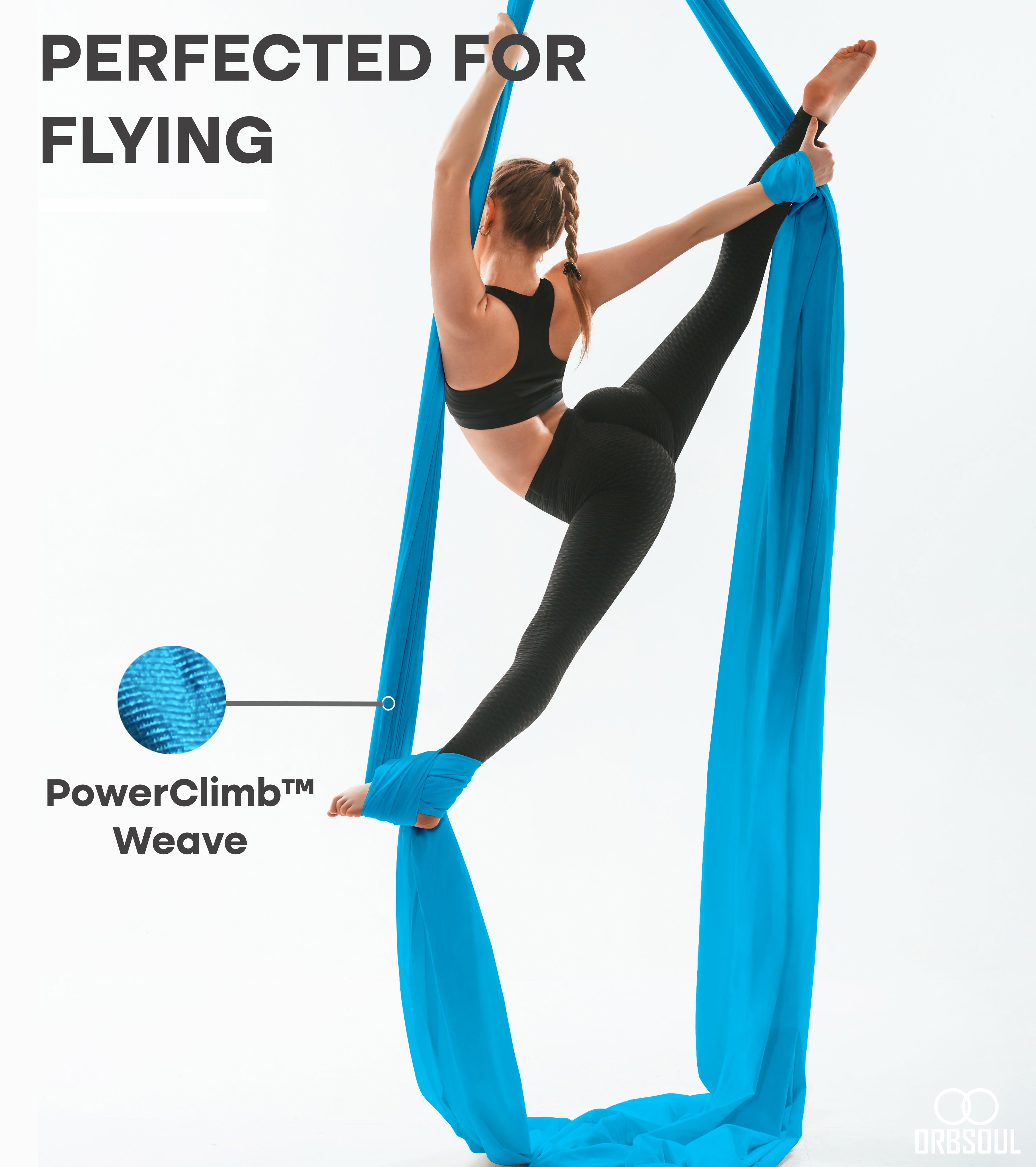 woman performing aerial art using aerial silks sky blue
